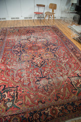Detail of distressed Ahar Heriz carpet with faded cherry red, navy, and varied blue curvilinear designs.