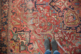 Decorative distressed Ahar Heriz carpet pile in cherry red, navy, and green geometric design.