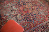 Distressed Ahar Heriz carpet, with cherry red field, worn pile, and intricate blue motifs.