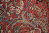 Textured distressed cherry red Ahar Heriz carpet, with geometric and curvilinear motifs.