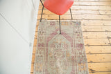 Distressed Oushak rug: faded violet hexagonal border, mint green field, frayed top fringe.