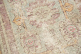 Distressed Oushak rug texture with even wear to knot heads and faded pastel tones.