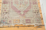 Faded mint and violet geometric floral border with tattered fringe on the distressed Oushak rug.