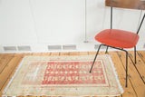 Distressed Oushak runner featuring faded cherry red, sand, and blush rose floral and diamond patterns.