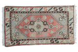 Distressed Oushak rug with a floral medallion in blush rose and slate blue hues.