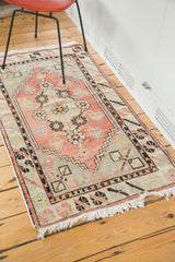 Distressed Oushak rug corner with slate blue geometric spandrel and blush field.