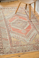 Geometric patterns with distressed texture in faded cinnabar and grey on Oushak rug.