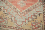 Faded cinnabar, grey, and beige geometric stepped patterns on distressed Oushak rug.