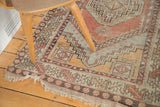 Decorative distressed fringed edge and geometric border on a faded Oushak rug.