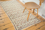 Distressed Oushak runner displaying repeating unidirectional floral motifs in muted tones.