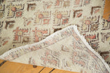 Distressed Oushak runner, folded to show hand-knotted foundation and faded floral texture.
