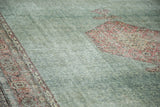 Distressed Oushak rug detail showing faded mallard green and blush patterned motifs.