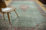 Distressed Oushak carpet corner with blush rose floral motifs, ivory, and beige leaf border.