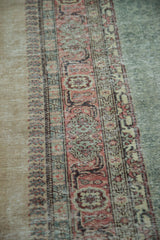 Distressed Oushak carpet border detail, beige outer edge, blush, green, slate blue motifs.
