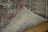 Distressed Oushak carpet corner showing worn blush pile and hand-knotted reverse.