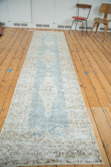 Distressed Oushak runner showing geometric floral border and faded powder blue field.