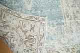 Distressed Oushak rug's secured side, revealing hand-knotted foundation and faded geometric pattern.