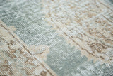 Distressed Oushak rug pile texture in muted teal, sand, and brown hues.