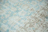 Distressed Oushak carpet detail, faded aqua field, blanched lotus motifs, muted beige border.