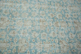 Blanched aqua field and muted floral design on a distressed Oushak hand-knotted rug.