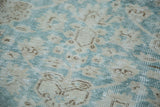 Distressed Oushak rug pile with faded aqua and beige abstract floral motifs.
