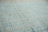 Soft aqua green distressed Oushak carpet with faded light floral motifs.