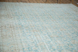 Distressed aqua green Oushak carpet with faded lotus flower patterns and textured pile.