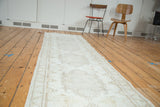 Long, distressed Oushak runner showing faded quintuplet medallions on an antique ivory field.