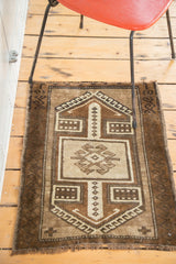 Vintage Oushak rug with mirrored geometric patterns and quadruple squares in sand, beige, brown.