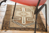 Hand-knotted vintage Oushak rug detail showing sand and beige tribal geometric patterns with quad column squares.