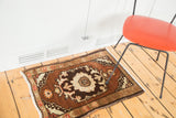 Vintage Oushak rug, chocolate brown field with floral spandrel motifs.