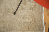 Soft sandy beige and bronze Oushak rug pile with subtle tone-on-tone pattern and secured edge.