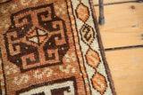 Ivory and tangerine hexagonal cartouches with serpent fills along the Oushak rug border.