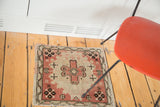 Blush rose pink and charcoal brown floral motifs on the Oushak mat corner.