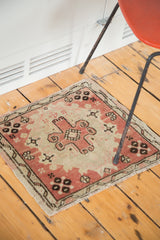 Blush rose pink field with sandy beige and bold charcoal floral motifs on a vintage Oushak rug.