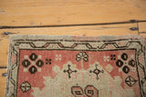 Blush pink Oushak rug's secured edge and geometric floral border.