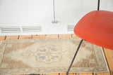 Vintage Oushak mat with hand-knotted texture, sand field, and denim blue geometric design.