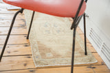 Ornate medallion, sand field, blue-green accents, and visible fringe on vintage Oushak rug mat.