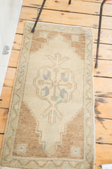 Vintage Oushak rug showing ornate medallion detail on a sand field with light brown border.