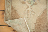 Hand-knotted vintage Oushak rug showing pile texture, woven backing, and secured edge.