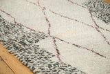 Plush ivory wool texture on a vintage Moroccan carpet, showing speckled grey and wine red lines.