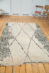 Plush shorn ivory wool pile and charcoal speckled border with wine red diamond outlines.