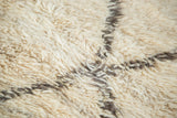 Thick, plush shaggy ivory wool pile with charcoal lattice design.