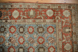 Vintage Veramin carpet corner: light blue field, rust-red border with birds and pomegranates.