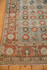 Light blue field and faded rust border with stylized bird and pomegranate motifs.