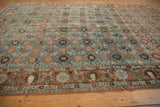 Vintage Veramin carpet's muted rust border with birds and pomegranates, merging into blue Mina Khani design.