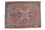 Distressed vintage Heriz carpet, red field, rams horn medallion, and soft blue floral tendrils.