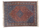 Vintage Shiraz carpet, tribal geometric diamond medallion, madder red and indigo blue patterns.