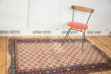 Distressed vintage Malayer rug, faded red blossoming flowers on an ivory field.