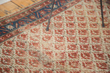 Distressed Malayer rug featuring ivory field, madder red blossoming patterns, and indigo border.